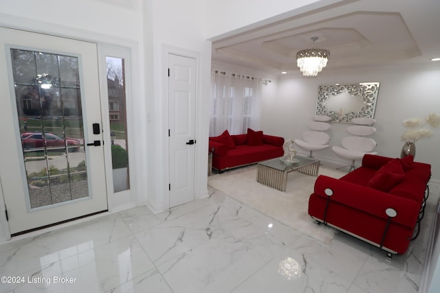 living room with a raised ceiling, ornamental molding, and an inviting chandelier