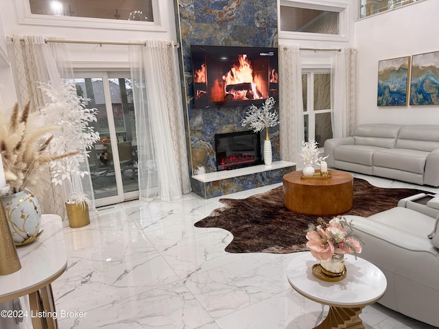 living room featuring a high ceiling and a high end fireplace