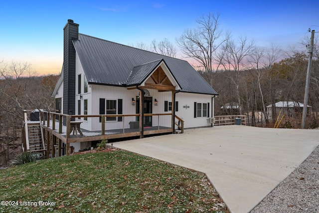 back house at dusk with a yard and a wooden deck