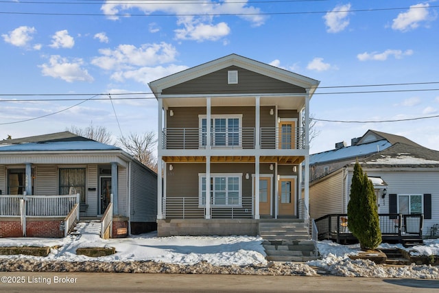 view of front property featuring a balcony and covered porch