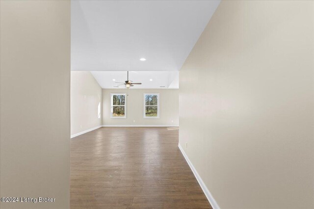 unfurnished living room with dark hardwood / wood-style flooring, vaulted ceiling, and ceiling fan