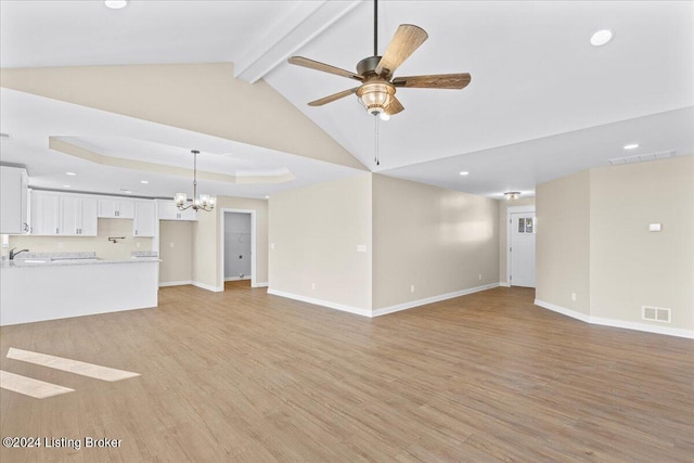 unfurnished living room with beamed ceiling, ceiling fan with notable chandelier, light wood-type flooring, and sink