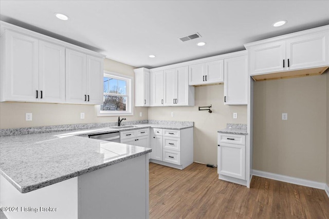 kitchen featuring sink, stainless steel dishwasher, light stone countertops, white cabinetry, and wood-type flooring