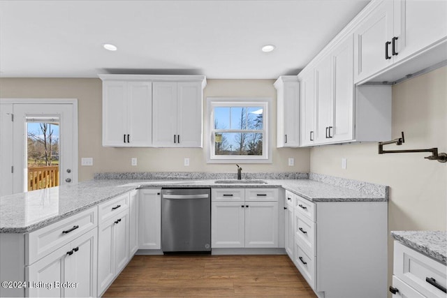 kitchen with hardwood / wood-style flooring, dishwasher, plenty of natural light, and kitchen peninsula