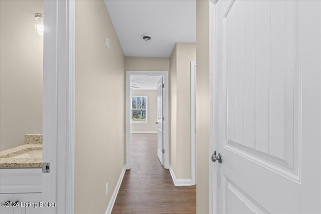 corridor with sink and dark wood-type flooring