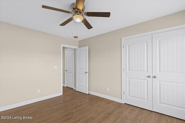 unfurnished bedroom featuring a closet, hardwood / wood-style floors, and ceiling fan