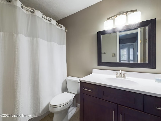 bathroom featuring toilet, vanity, a textured ceiling, and tile patterned floors