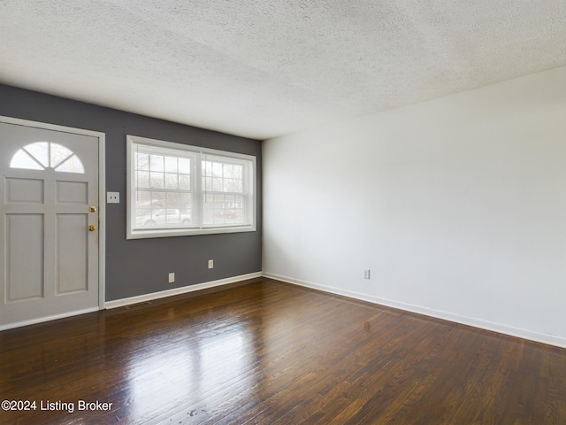 foyer entrance featuring dark hardwood / wood-style floors, a healthy amount of sunlight, and a textured ceiling