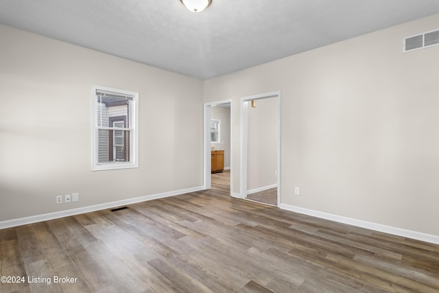 spare room with wood-type flooring and a textured ceiling