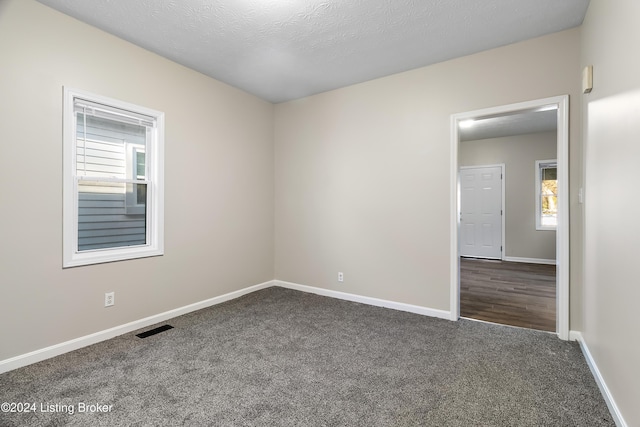 carpeted spare room with a textured ceiling