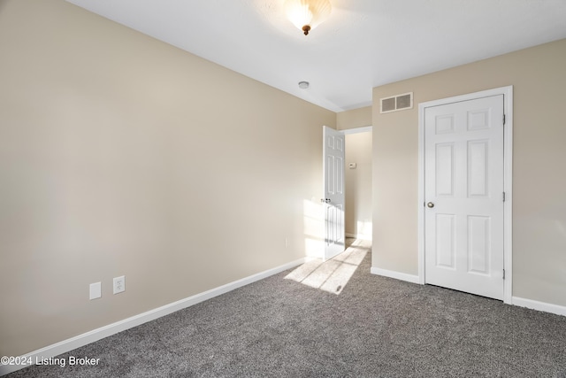 unfurnished bedroom with dark carpet