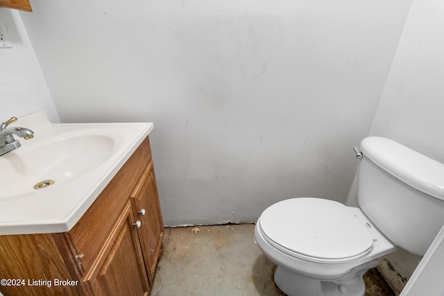 bathroom with vanity, toilet, and concrete flooring