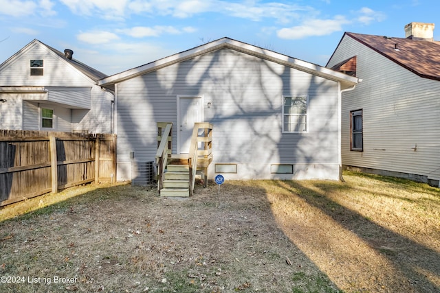 rear view of property featuring a yard