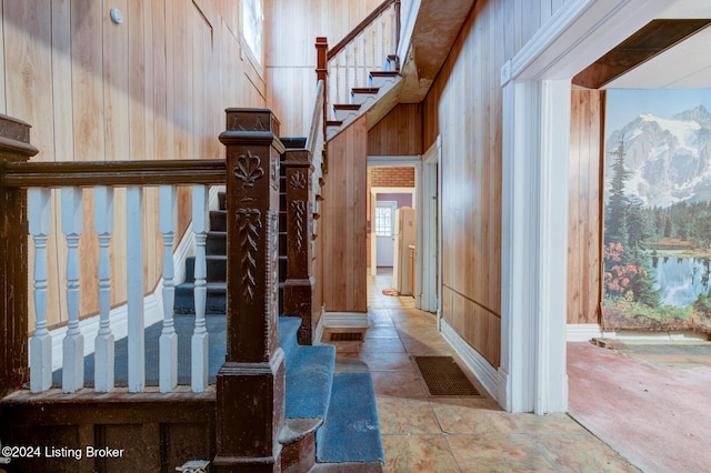 staircase featuring wood walls