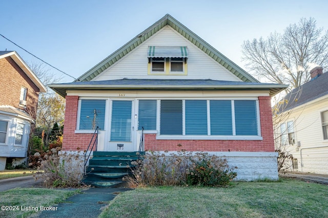 bungalow-style house featuring a front lawn