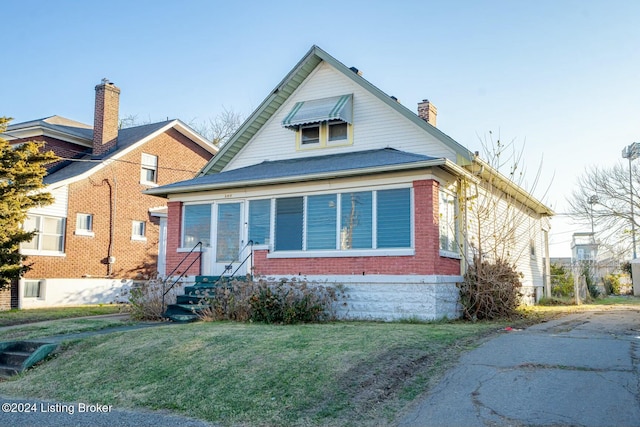 bungalow-style home featuring a front yard