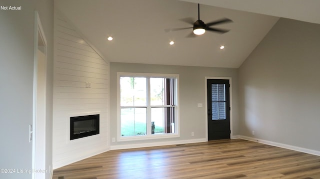 unfurnished living room with hardwood / wood-style floors, ceiling fan, a fireplace, and high vaulted ceiling