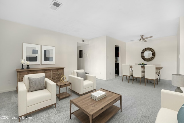 living room with ceiling fan and light colored carpet