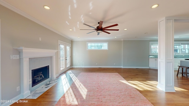 living room with light hardwood / wood-style floors, ceiling fan, and ornamental molding