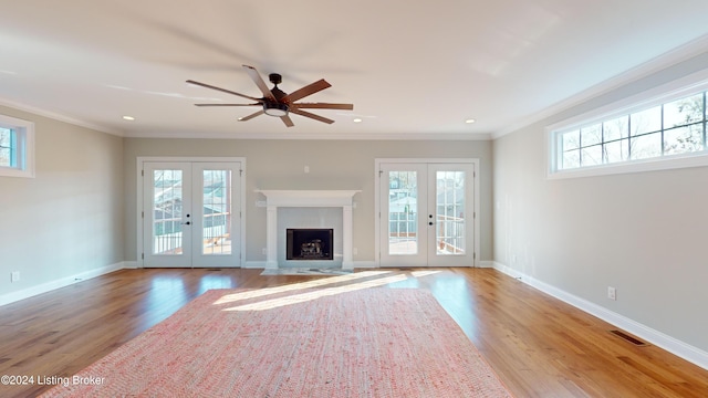 unfurnished living room with french doors, light hardwood / wood-style flooring, and crown molding