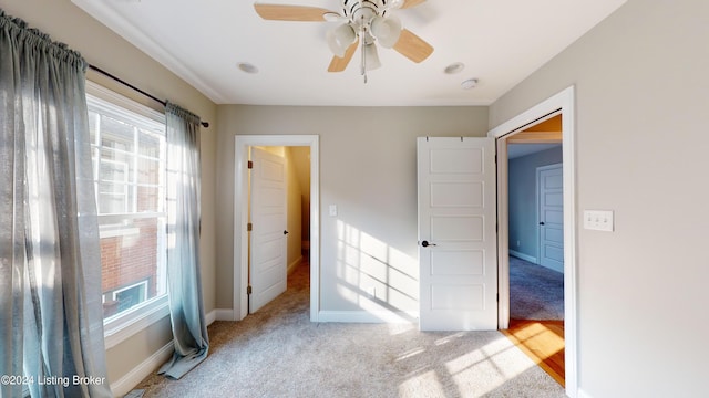 unfurnished bedroom with ceiling fan, a closet, and light carpet