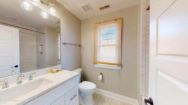 bathroom featuring a tile shower, tile patterned flooring, vanity, and toilet