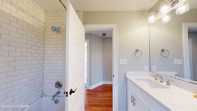 bathroom featuring vanity, hardwood / wood-style flooring, and tiled shower / bath combo