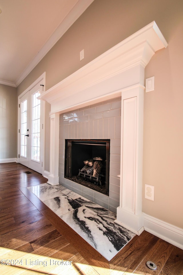 room details with a fireplace, crown molding, hardwood / wood-style floors, and french doors