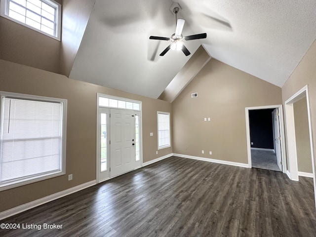 foyer entrance featuring a textured ceiling, ceiling fan, dark wood-type flooring, and high vaulted ceiling