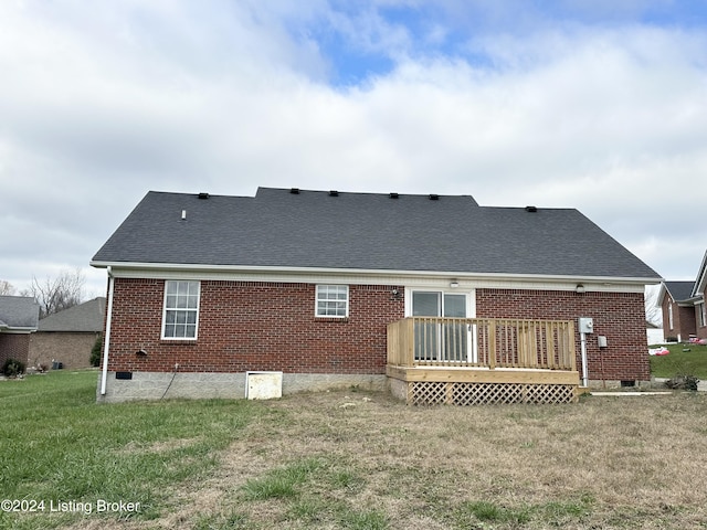 back of property with a deck and a lawn