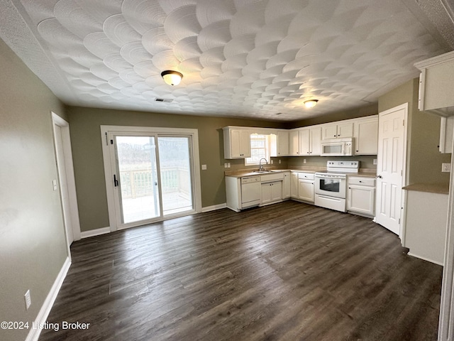 kitchen featuring a textured ceiling, white appliances, sink, white cabinets, and dark hardwood / wood-style floors