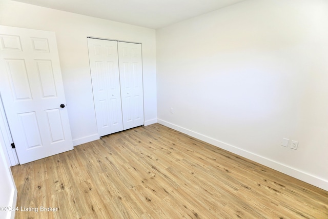 unfurnished bedroom with a closet and light hardwood / wood-style floors