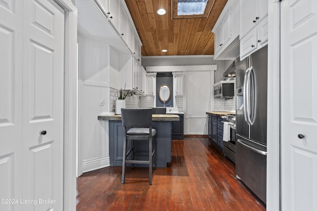 kitchen featuring dark hardwood / wood-style flooring, white cabinets, and appliances with stainless steel finishes