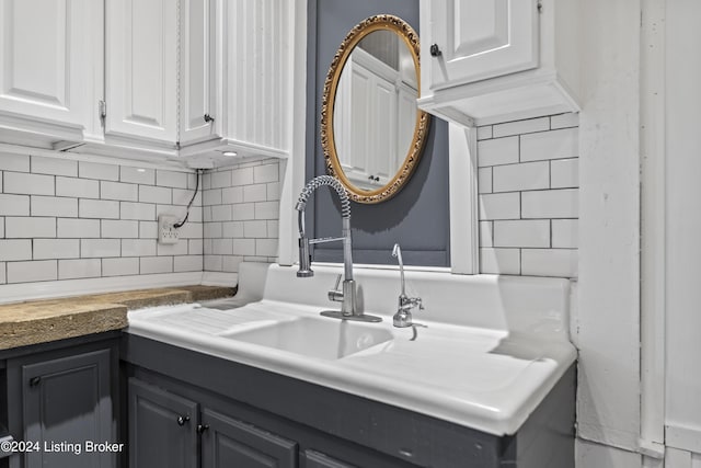 bathroom featuring vanity and backsplash