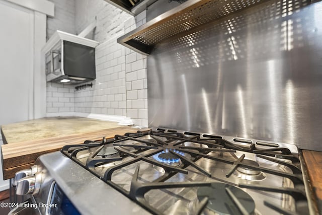 details featuring stainless steel gas stovetop and backsplash