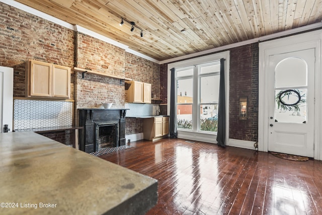 kitchen featuring dark hardwood / wood-style floors, brick wall, backsplash, and light brown cabinetry