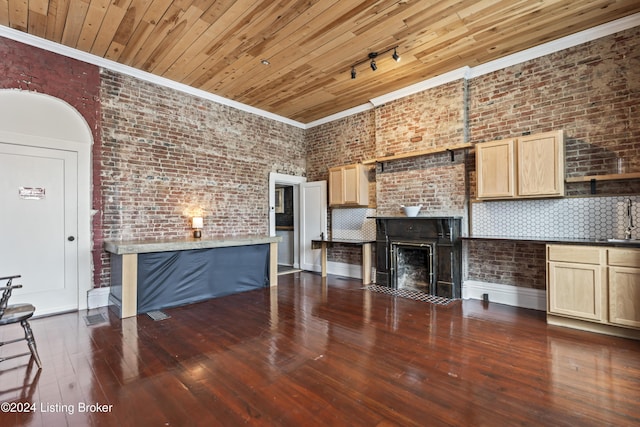 unfurnished living room with sink, dark hardwood / wood-style flooring, ornamental molding, and brick wall