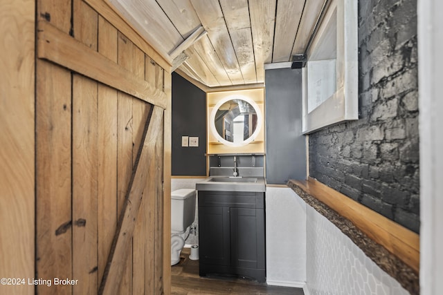 interior space with dark hardwood / wood-style flooring, wood ceiling, and sink