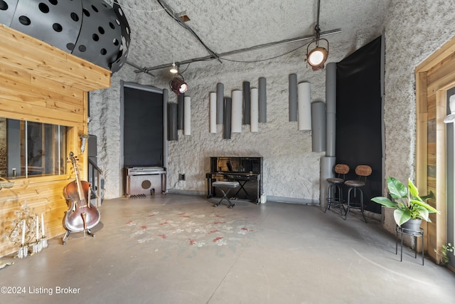 unfurnished living room featuring concrete flooring and a high ceiling