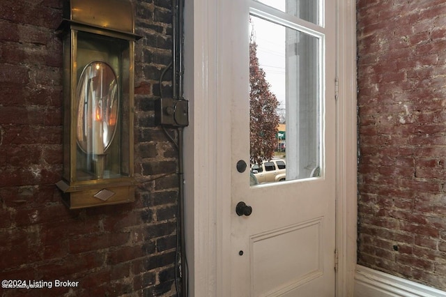 doorway to outside featuring brick wall