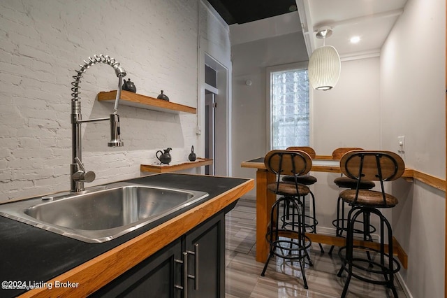 kitchen with hardwood / wood-style floors, pendant lighting, and sink