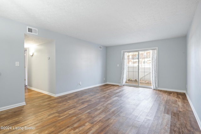 empty room with a textured ceiling and hardwood / wood-style flooring