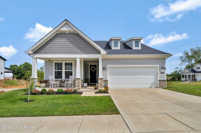 craftsman house with a front lawn, a porch, and a garage