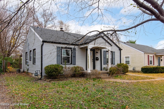 view of front of house featuring central air condition unit and a front lawn