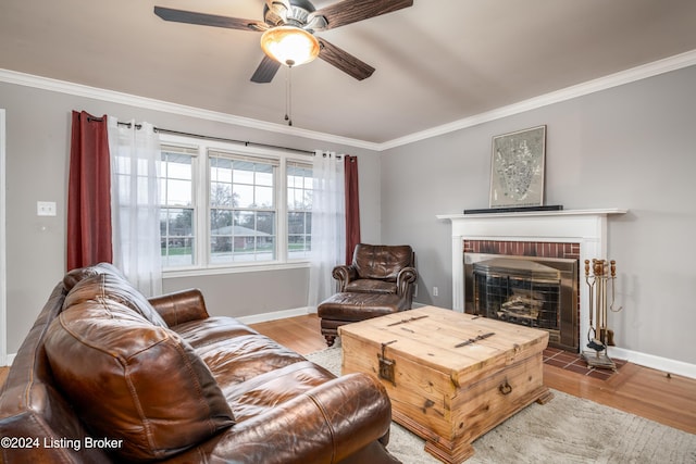 living room with a brick fireplace, ceiling fan, and ornamental molding