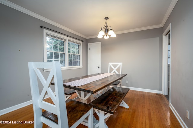 dining room featuring crown molding, light hardwood / wood-style floors, and an inviting chandelier