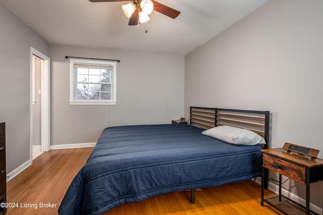 bedroom with ceiling fan, light hardwood / wood-style floors, and lofted ceiling