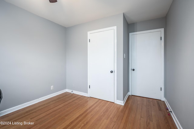 unfurnished bedroom featuring a closet, light hardwood / wood-style flooring, and ceiling fan