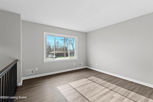 empty room with dark hardwood / wood-style flooring