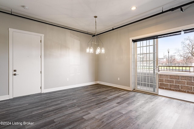 unfurnished dining area featuring wood-type flooring and an inviting chandelier